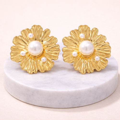 Boucles d’oreilles florales dorées en acier inoxydable avec perles blanches sur socle en marbre